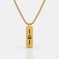 A gold-toned rectangular pendant necklace with a black Trishul symbol in the center, suspended from a matching gold chain against a light gray background.