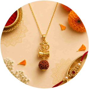Gold-toned necklace with an Om symbol, a small bell charm, and a brown rudraksha bead pendant, arranged on a beige decorative background with orange flowers and a red-and-gold Rakhi.