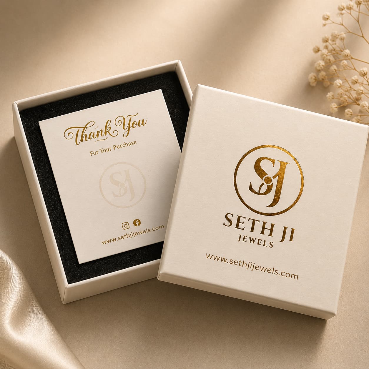 A premium jewelry gift box set from Seth Ji Jewels, featuring a white outer box with gold foil branding and a matching inner box with a thank you card, styled on a beige satin fabric background.