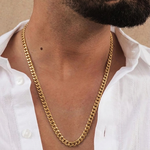 Gold chain necklace worn by a person with a white shirt