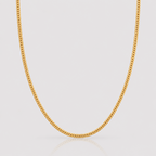 Gold chain necklace on a light gray background