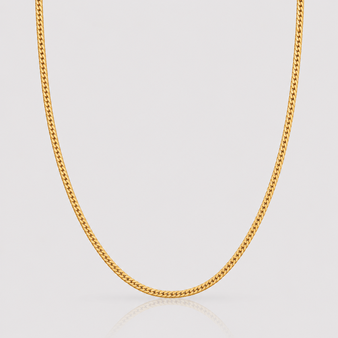 Gold chain necklace on a light gray background