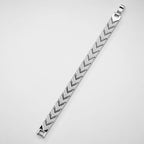 A silver-toned metal bracelet with a textured chevron or herringbone pattern, shown diagonally on a plain light gray background.
