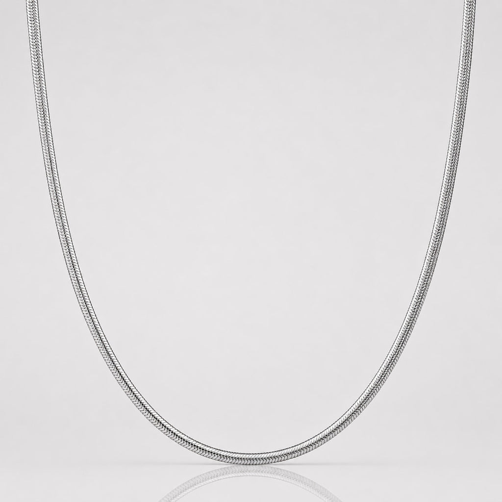 Silver chain necklace on a light gray background