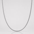 Silver chain necklace on a light gray background