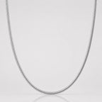 Silver chain necklace on a light gray background
