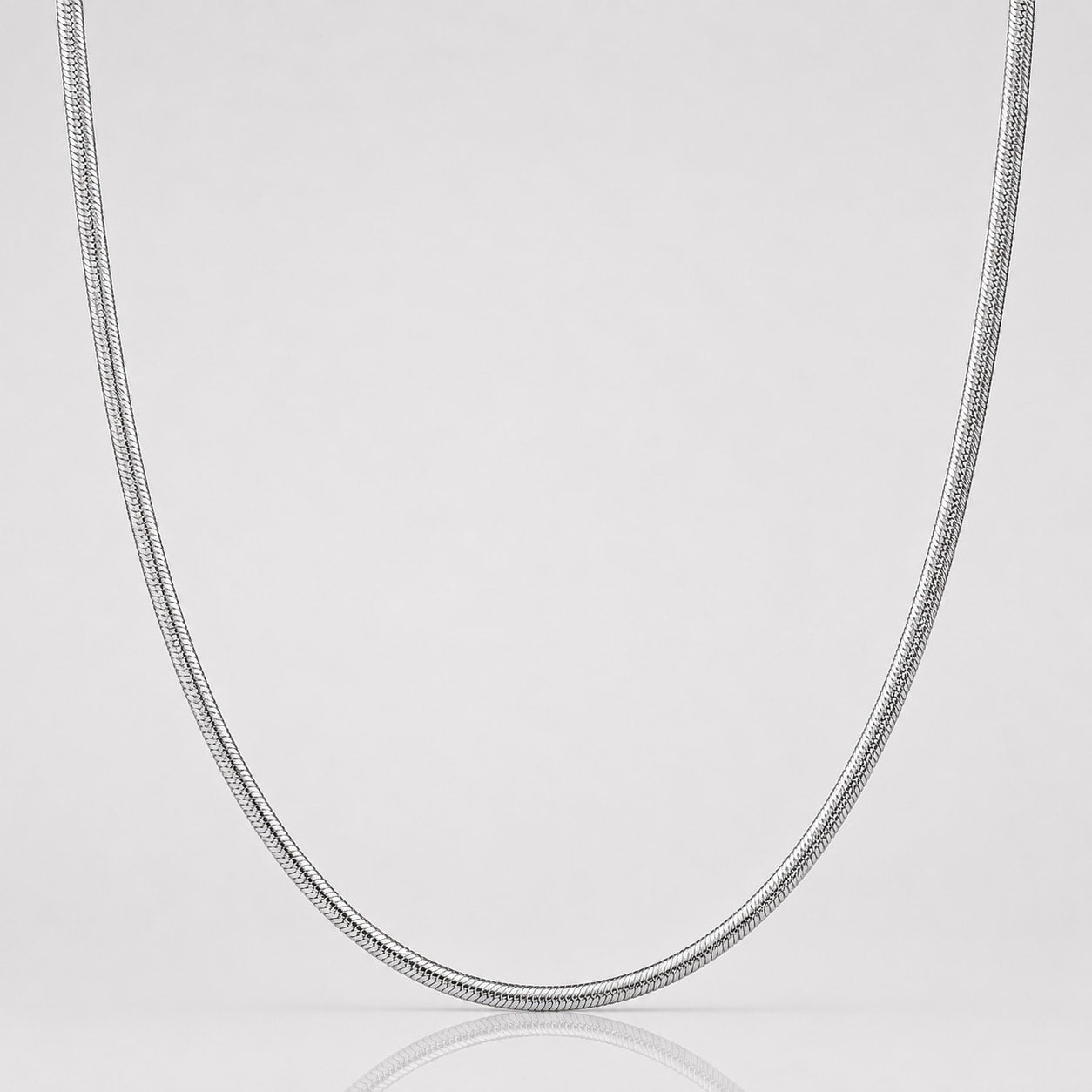 Silver chain necklace on a light gray background